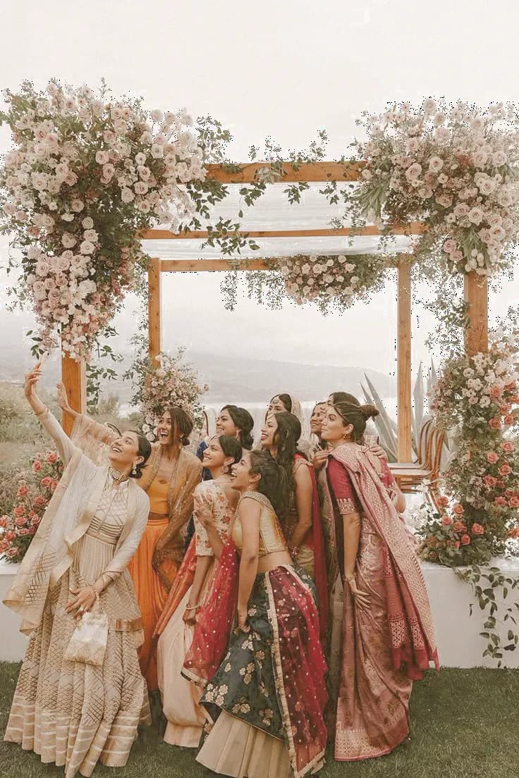 Friends Gathered Beneath A Flower-Covered Wedding Mandap